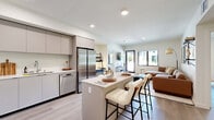 Located at 127 W Pomona Ave in Monrovia, CA, this thoughtfully designed 2-bedroom, 2-bathroom residence offers a clean, contemporary aesthetic throughout its single-floor layout. The open-concept kitchen is outfitted with flat-front cabinetry in a warm neutral tone, stainless steel appliances including a built-in microwave, range, and dishwasher, and a generous island with a white quartz countertop — ideal for both meal prep and casual dining. Light wood-style flooring runs throughout the main living areas, enhancing the bright, airy feel of the space. The living room is filled with natural light from large windows and a glass door that opens directly to an outdoor area with views of the surrounding community. Both bedrooms are well-proportioned, with the primary bedroom featuring a spacious sliding-door closet and access to a hallway, while both rooms benefit from windows that frame outdoor greenery. The two bathrooms are finished with striking floor-to-ceiling marble-look wall surrounds above deep soaking tubs, complemented by chrome fixtures and clean-lined vanities. The overall ambiance is calm and modern, with a neutral palette and quality finishes that lend a polished, move-in-ready feel throughout.