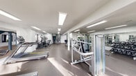 Located at 1500 Lorene Dr in Harvey, Louisiana, this fitness center offers a spacious, single-floor exercise facility designed to support a full range of workout routines. The space is finished with a clean, modern aesthetic, featuring crisp white walls, recessed flush-panel lighting, and durable rubberized flooring throughout that provides both comfort and functionality.

The facility is comprehensively equipped with a wide variety of cardio machines, including Matrix-brand treadmills, elliptical trainers, and upright stationary bikes. A dedicated strength training area features Matrix cable and resistance machines, an adjustable weight bench, and a well-stocked dumbbell rack with a full range of free weights. An accessory wall organizes resistance bands, kettlebells, medicine balls, and stability equipment for versatile training options.

Full-length mirrors line one wall of the strength area, visually expanding the space while allowing users to monitor their form. Large windows along the perimeter invite natural light and offer outdoor views of the surrounding landscape, enhancing the open, airy atmosphere. Potted tropical plants are positioned near the entrance, adding a welcoming touch of greenery.

The layout is thoughtfully arranged to maximize floor space and traffic flow, allowing multiple users to exercise simultaneously without congestion. Overall, the facility presents a clean, professional environment well-suited for a comprehensive fitness experience.