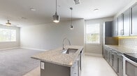 Located at 7995 Haven Way in Kissimmee, FL, this well-appointed one-bedroom, one-bathroom residence offers a thoughtfully designed single-floor layout with modern finishes throughout. The open-concept kitchen and living area forms the heart of the home, centered around a striking granite-topped island with an undermount sink and dual pendant lights overhead. Sleek gray cabinetry lines the kitchen walls, complemented by a white subway tile backsplash, under-cabinet lighting, and a full suite of stainless steel appliances including a refrigerator, range, and microwave. Light wood-look flooring flows through the kitchen and living areas, transitioning to plush carpet in the living room, which features a ceiling fan and natural light from multiple windows. The bedroom is generously sized, carpeted, and bathed in natural light from two large windows with views of greenery outside. A ceiling fan adds to the comfort of this restful retreat. The bathroom includes a soaking tub with clean white shiplap-style tile surround. A spacious closet with paneled double doors provides ample storage. Neutral wall tones and consistent modern detailing create a cohesive, move-in-ready atmosphere throughout the entire space.