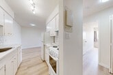 This well-appointed one-bedroom, one-bathroom unit in Chilliwack, BC offers a clean, modern aesthetic throughout its efficiently designed single-level layout. Fresh light-toned vinyl plank flooring runs seamlessly throughout the space, enhancing the bright and airy atmosphere created by the neutral white and soft beige walls.

The open living area is a standout feature, anchored by a full-width sliding glass door that opens to a private balcony overlooking lush trees and mountain views. Baseboard heating lines the perimeter, and a textured ceiling adds a classic touch to the generous living space.

The kitchen is thoughtfully laid out with crisp white cabinetry, subway tile backsplash, a marble-look countertop, and white appliances including a fridge and electric range. A track lighting fixture overhead ensures the kitchen is well-lit.

The bedroom is a comfortable, well-sized room featuring a large closet with built-in shelving, a window framing pleasant outdoor views, and continued vinyl plank flooring. The bathroom includes elegant large-format marble-look tile work, adding a refined touch to the unit.

A separate walk-in storage closet with built-in shelving provides practical organization space. Overall, this unit combines clean finishes, natural light, and functional design in a convenient Chilliwack location.