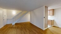 Located at 111 Cleaveland Rd in Pleasant Hill, CA, this two-story, 2-bedroom, 2-bathroom home offers a practical and comfortable layout spread across two floors. The main level features a bright, open living room with warm wood-look flooring, a textured ceiling, and a white-railed staircase that adds a clean, classic touch. A sliding glass door floods the living area with natural light and opens to an outdoor deck with views of surrounding greenery, while an additional window and a wall-mounted HVAC unit round out the space. The galley-style kitchen is well-appointed with warm wood cabinetry, white quartz countertops, a stainless steel refrigerator, recessed lighting, and tile flooring — offering efficient use of space. Two bathrooms serve the home, one featuring a tub/shower combo with tile flooring and a vanity with wood cabinetry. Upstairs, the two bedrooms continue the wood-look flooring theme and are filled with natural light from large windows with outdoor views. The generously sized primary bedroom provides ample space for furnishings. A hallway, closet, and second staircase complete the upper level, making the overall layout functional and well-organized throughout.