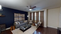Located at 2416 Fort Worth Ave in Dallas, TX, this single-floor residence presents a cohesive and thoughtfully designed interior. The living area makes an immediate impression with a striking navy blue accent wall that serves as a backdrop for the space, complemented by rich, dark hardwood flooring throughout. A ceiling fan with integrated lighting anchors the room, while multiple windows dressed in layered brown curtains and blinds allow for controlled natural light.

The kitchen is designed for functionality and style, featuring dark espresso cabinetry paired with white countertops and a large island with a double undermount sink. Stainless steel appliances, including a refrigerator, range, and microwave, complete the well-equipped cooking space. The kitchen flows seamlessly toward the living and dining areas.

The bedroom is a calm retreat, finished with soft, neutral walls, plush carpeting, and a ceiling fan. Multiple windows bring in natural light, and the room offers generous space for furnishings. The adjoining bathroom includes a soaking tub and shower combination, a dark-framed vanity mirror, white countertops, and direct access to a walk-in closet with built-in shelving.