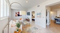 Located at 2500 SW 22nd Terrace in Fort Lauderdale, FL, this well-appointed one-bedroom, one-bathroom residence offers a thoughtfully designed layout with modern finishes throughout. The open-concept living area is filled with natural light from large windows that frame scenic outdoor views, creating an airy and inviting atmosphere. Light-toned tile flooring runs throughout the space, complementing the neutral color palette on the walls. The living room offers generous space for both lounging and a dedicated workspace, with a private balcony accessible through a sliding glass door. The kitchen is a standout feature, showcasing a bold navy tile backsplash, two-tone cabinetry combining white upper cabinets with warm wood lower cabinets, quartz countertops, stainless steel appliances, and a curved peninsula with bar seating — ideal for casual dining and entertaining. The bedroom is a serene retreat with a tray ceiling, ceiling fan, and a cozy, well-proportioned layout. The bathroom is clean and modern, featuring large-format tile flooring, a glass-enclosed shower, and a sleek vanity with ample storage. An in-unit washer and dryer add everyday convenience to this polished Fort Lauderdale residence.