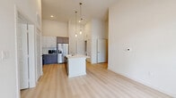 Located at 707 W Slaughter Lane in Austin, TX, this well-appointed 2-bedroom, 2-bathroom residence offers a thoughtfully designed single-level layout. The open-concept kitchen serves as the heart of the home, showcasing a large center island with a white quartz countertop and integrated sink, crisp white upper cabinetry paired with dark wood lower cabinets, a classic subway tile backsplash, and stainless steel appliances including a French door refrigerator and gas range. Soaring ceilings with pendant lighting and recessed fixtures lend the living and kitchen area an airy, expansive feel. Light wood-style flooring runs consistently throughout, enhancing the home's bright and cohesive aesthetic. Both bedrooms are well-proportioned, featuring neutral walls, the same warm flooring, and windows with blinds that frame views of the surrounding greenery. The primary bathroom is generously sized, offering a dual-option layout with both a glass-enclosed walk-in shower and a soaking tub, complemented by a dark wood vanity with white countertop and a large framed mirror. The second bathroom mirrors the modern design with a single vanity and clean finishes. A dedicated closet adds practical storage to round out this functional, contemporary residence.