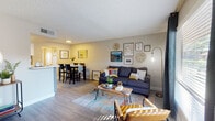 Located at 3555 N First Ave in Tucson, Arizona, this single-floor residence offers a thoughtfully designed layout that balances comfort and functionality. The open-concept living and dining area provides a welcoming atmosphere, with wood-look flooring, a textured ceiling, and a large window dressed in navy curtains that frames a view of the outdoor pool area, filling the space with natural light. A dedicated entryway with additional storage leads seamlessly into the main living zone.

The galley-style kitchen is outfitted with two-tone cabinetry — white uppers and grey lowers — complemented by quartz countertops, a decorative tile backsplash, and stainless steel appliances including a gas range and refrigerator. A pass-through counter connects the kitchen to the dining area, enhancing the open feel.

Both bedrooms are carpeted and comfortably sized, each featuring natural light from large windows with blinds and curtains. The bedrooms share a clean, modern bathroom appointed with a grey vanity, quartz countertop, and wood-look tile flooring.

Throughout the residence, neutral warm tones and consistent finishes create a cohesive and inviting ambiance, making this Tucson property a functional and attractive living space.