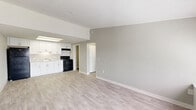 Located in Miami, FL, this single-floor 1-bedroom, 1-bathroom unit offers a clean, functional layout designed to maximize every square foot. The open-concept living and kitchen area forms the heart of the home, featuring light wood-style laminate flooring that runs throughout, neutral gray textured walls, and a textured ceiling that adds subtle character. The kitchen is outfitted with crisp white cabinetry, light-toned countertops, a stainless sink, and black appliances including a refrigerator, electric range, and overhead range hood, all illuminated by a recessed ceiling light fixture. The living area flows seamlessly from the kitchen, offering a bright, open feel. The bedroom is a comfortable, well-proportioned room with a ceiling fan, a window that allows natural light, and access to a closet. A hallway connects the main living areas to the bedroom and bathroom, with two closets providing generous storage. The bathroom features a combined tub and shower, a white vanity with storage below, and matching light wood-style flooring. A dedicated utility room adds practical functionality. The overall design is neutral, clean, and move-in ready.