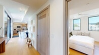 Located in the heart of West Hollywood, this thoughtfully designed 2-bedroom, 2-bathroom residence offers a refined blend of modern architecture and warm, natural materials. Wide-plank wood flooring flows throughout, complementing the clean white walls and creating a cohesive, welcoming ambiance.

The open living room is bathed in natural light through floor-to-ceiling black-framed windows that frame scenic views of the Hollywood Hills. The kitchen features a sleek, contemporary layout with light wood and white cabinetry, quartz countertops, a marble-style backsplash, stainless steel appliances, and a breakfast bar with gold-accented seating — ideal for casual dining.

The primary bedroom offers a serene, hotel-like atmosphere with a padded upholstered headboard wall and warm wood flooring, while the second bedroom benefits from dual black-framed windows showcasing panoramic views of the surrounding hillside neighborhood. Both bedrooms include ample closet storage with light wood panel doors.

The two bathrooms are finished to a high standard: one features a walk-in rain shower with large-format stone tile, while the other offers a soaking tub with a glass enclosure and gold hardware accents, paired with a floating wood vanity and white quartz countertop. This residence delivers a polished, contemporary lifestyle in one of Los Angeles' most vibrant neighborhoods.