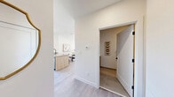 This well-appointed 1-bedroom, 1-bathroom unit is designed with a clean, modern aesthetic throughout its single floor. The open-concept kitchen and living area serves as the heart of the home, where light wood cabinetry, quartz countertops, and stainless steel appliances define the kitchen. A peninsula with bar seating provides both additional prep space and a casual dining option. Light hardwood-style flooring flows seamlessly throughout the main living areas, enhancing the sense of continuity and brightness. The living room is bathed in natural light from a large bank of windows offering urban views, creating an inviting and airy atmosphere. Elevated ceilings in portions of the living area add a sense of openness beyond the unit's compact footprint. The bedroom features a window with city views, light-toned walls, and warm hardwood flooring, offering a calm and comfortable retreat. A dedicated closet provides practical storage. The bathroom is finished with large-format tile flooring, a wood-toned vanity with a white countertop, and clean white walls, contributing to the unit's cohesive contemporary style. Every room reflects thoughtful design choices that maximize both functionality and visual appeal.