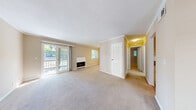 Located in Concord, CA, this single-floor residence offers a well-designed layout that balances comfort and functionality throughout. The generous living room is a standout feature, highlighted by a fireplace with a clean white surround, sliding glass doors that invite abundant natural light and provide direct access to an outdoor balcony, and an additional window that further brightens the space. Crown molding adds a refined touch throughout the living areas. The galley-style kitchen is efficiently appointed with white cabinetry, granite-look countertops, stainless steel appliances including a refrigerator and dishwasher, an electric range, and tile flooring. A pass-through opening connects the kitchen to an adjacent dining or flex area, enhancing the open feel. The bedrooms are carpeted and well-proportioned, each featuring ceiling fans and windows with views of surrounding greenery. One room includes a convenient in-unit washer and dryer closet, adding to everyday practicality. The bathroom features a full tub-shower combination with classic white tile surround, a granite-look vanity countertop, and neutral tile flooring. Warm beige tones and crown molding carry throughout, creating a cohesive and inviting ambiance across the entire home.