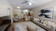 Located at 3126A E Valley Water Mill Rd in Springfield, Missouri, this single-story residence offers a thoughtfully designed open-concept layout that seamlessly connects the main living spaces. The living room is bright and welcoming, featuring a ceiling fan with light fixture, a textured ceiling, and a large window dressed with blinds that allows natural light to filter in and offers a view of the surrounding greenery. Neutral-toned walls and a mix of carpet and hardwood-style flooring create a warm, cohesive ambiance throughout.

The kitchen is efficiently laid out in an L-shape and includes ample white cabinetry for storage, a black electric range, a built-in microwave, a dishwasher, a refrigerator, and a double sink. A peninsula with bar stool seating bridges the kitchen to the living area, making it ideal for casual dining or entertaining. Adjacent to the kitchen is a dedicated dining nook with hardwood-style flooring and closet storage nearby.

The bedroom is carpeted and comfortably sized, featuring a window with natural light and a textured ceiling. Throughout the residence, the design emphasizes functionality and comfort, with a clean, neutral palette that provides a versatile backdrop for personalizing the space.