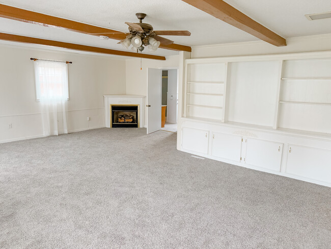 Expansive living room with lots of natural light, exposed beams, fireplace, and gorgeous built-ins - 8 Charing Cross Rd