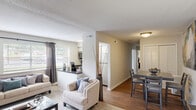 Located at 501 Highway 54 in Carrboro, NC, this single-floor, 2-bedroom, 1-bathroom home offers a practical and comfortable layout with thoughtful design throughout. The open-concept kitchen and living area serves as the heart of the home, where the kitchen features stainless steel appliances—including a range, microwave, and refrigerator—white cabinetry, dark countertops, and hardwood-style flooring, all brightened by natural light from multiple windows. The adjoining living and dining area transitions between carpet and hardwood-style flooring and features a textured ceiling, neutral walls, and a window that fills the space with natural light. The primary bedroom is a well-sized retreat with plush carpeting, natural light from a window, and dual closets offering generous storage. The second bedroom is equally comfortable, with soft carpet, a window, and a clean, neutral palette. The shared full bathroom is equipped with a tub-shower combination with a curtain rod, modern fixtures, and hardwood-style flooring. Throughout the home, clean lines, neutral tones, and consistent finishes create a cohesive and move-in-ready atmosphere well-suited for comfortable everyday living.