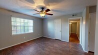 Located at 200 N Hills St in Meridian, Mississippi, this single-story, 3-bedroom, 2-bathroom home offers a practical and comfortable layout. The interior is finished with a mix of hardwood-style flooring in the main living and kitchen areas and wall-to-wall carpeting in all three bedrooms, providing a warm and cozy feel underfoot.

The kitchen is well-equipped with ample white cabinetry offering generous storage, white countertops, and a full suite of black appliances including a refrigerator, dishwasher, electric range, and over-the-range microwave. A double-basin sink sits beneath a window that lets in natural light, brightening the space.

The bedrooms feature neutral gray walls, textured ceilings, and carpet flooring. The primary bedroom is a comfortable size and includes a ceiling fan with light fixture and a window with outdoor views. The secondary bedrooms are similarly appointed with windows that bring in natural light.

The two bathrooms include one full bath with a tiled tub/shower combo and one bath featuring a wall-mounted sink with a medicine cabinet mirror. A central hallway connects the rooms, contributing to an efficient and easy-to-navigate floor plan. The home's straightforward design makes it a functional and livable space throughout.