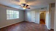 Located at 200 N Hills St in Meridian, Mississippi, this single-story, 3-bedroom, 2-bathroom home offers a practical and comfortable layout. The interior is finished with a mix of hardwood-style flooring in the main living and kitchen areas and wall-to-wall carpeting in all three bedrooms, providing a warm and cozy feel underfoot.

The kitchen is well-equipped with ample white cabinetry offering generous storage, white countertops, and a full suite of black appliances including a refrigerator, dishwasher, electric range, and over-the-range microwave. A double-basin sink sits beneath a window that lets in natural light, brightening the space.

The bedrooms feature neutral gray walls, textured ceilings, and carpet flooring. The primary bedroom is a comfortable size and includes a ceiling fan with light fixture and a window with outdoor views. The secondary bedrooms are similarly appointed with windows that bring in natural light.

The two bathrooms include one full bath with a tiled tub/shower combo and one bath featuring a wall-mounted sink with a medicine cabinet mirror. A central hallway connects the rooms, contributing to an efficient and easy-to-navigate floor plan. The home's straightforward design makes it a functional and livable space throughout.