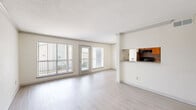 Located at 10225 Bissonnet St in Houston, TX, this one-bedroom, one-bathroom unit offers a thoughtfully organized single-floor layout. The open-concept living room and kitchen area serves as the heart of the home, featuring light wood-style flooring, neutral white walls, and large windows paired with a glass-panel door that opens to a private balcony, flooding the space with natural light and outdoor views. Crown molding adds a subtle architectural detail throughout the living area.

The kitchen is positioned adjacent to the living room and features warm wood cabinetry, granite-style countertops, and black appliances including a refrigerator, range, and dishwasher, maximizing functionality in a compact, galley-style layout.

The bedroom is a comfortable, carpeted retreat equipped with a ceiling fan with light fixture and a window offering natural light. It connects to a generously sized walk-in closet with built-in shelving and hanging rods, providing ample storage. The full bathroom includes a tiled tub-and-shower combination with warm earth-toned tile, a toilet, and wood-accented vanity. A hallway connects the private and shared spaces, completing this efficient and comfortable layout.