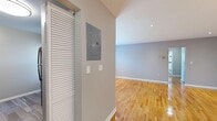 Located at 21 Lancaster Ct in Wayne, NJ, this 2-bedroom, 1-bathroom residence offers a well-organized single-floor layout finished with warm hardwood flooring throughout. The inviting living room features recessed lighting, a stylish pendant chandelier, and soft gray walls that create a clean, neutral ambiance. Natural light filters in through blinded windows, enhancing the brightness of each room.

The kitchen is equipped with rich dark wood cabinetry, a light stone countertop, a stainless steel sink, gas range, and a full-size stainless steel refrigerator, complemented by a subtle tile backsplash and light wood-toned flooring. Both bedrooms are comfortably sized, with the spacious primary bedroom featuring dual closets for generous storage. Each bedroom includes a window unit for climate control and a baseboard heating system.

The bathroom is neatly appointed with white tile walls accented by a decorative gray and brown tile border, a soaking tub with shower, and a natural-light window. Hallways connect the rooms efficiently, and a dedicated entrance with a louvered closet door and electrical panel adds practical utility. The overall design is clean and move-in ready.