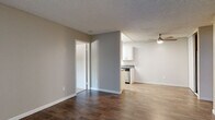 This single-floor unit in Hayward, California offers a functional and comfortable layout designed for everyday living. The living area features rich, dark hardwood-style flooring, neutral warm-toned walls, and a textured ceiling, creating an inviting atmosphere. A ceiling fan adds comfort to the space, while a sliding glass door opens to a private patio, filling the room with natural light and providing easy outdoor access. A wall-mounted air conditioning unit ensures year-round climate control.

The galley-style kitchen is efficiently designed with white cabinetry, dark granite-style countertops, stainless steel appliances including a range and refrigerator, and light wood-style flooring. Overhead lighting brightens the workspace, and ample cabinet storage lines both sides of the kitchen.

The bedrooms are finished with plush carpet and feature windows that invite natural light. Baseboard heating is present throughout, offering consistent warmth. Each bedroom includes closet space for practical storage.

The bathroom is clean and well-appointed, showcasing white cabinetry with a dark countertop, a mirrored medicine cabinet, chrome fixtures, and a full tub-shower combination. Wood-style flooring carries through this space for a cohesive look. Overall, the unit presents a tidy, move-in ready environment in a convenient Bay Area location.