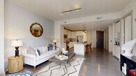 Located at 1575 Anderson Rd in McLean, VA, this well-appointed one-bedroom, one-bathroom residence offers a thoughtfully designed open-concept layout across a single floor. Hardwood flooring flows throughout the main living areas, anchoring a bright and cohesive interior.

The living room provides a comfortable and stylish gathering space, featuring track lighting and large floor-to-ceiling windows with sliding glass door access to a private balcony, flooding the room with natural light and offering views of the surrounding neighborhood.

The kitchen is a standout feature, showcasing white shaker cabinetry, a classic tile backsplash, stainless steel appliances including a refrigerator, microwave, and range, and a generous island with light quartz countertops. Pendant lighting above the island and recessed ceiling lights enhance the space, while bar seating makes it ideal for casual dining and entertaining.

The bedroom is a serene retreat with plush carpeting, a ceiling fan, and a neutral color palette accented by a bold feature wall. It connects directly to the bathroom, which features rich dark wood cabinetry, dual sinks with a wide vanity mirror, and elegant tile flooring. A dedicated closet completes the private quarters, providing practical storage in this efficiently designed McLean residence.