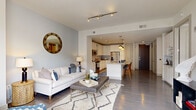 Located at 1575 Anderson Rd in McLean, VA, this well-appointed one-bedroom, one-bathroom residence offers a thoughtfully designed open-concept layout across a single floor. Hardwood flooring flows throughout the main living areas, anchoring a bright and cohesive interior.

The living room provides a comfortable and stylish gathering space, featuring track lighting and large floor-to-ceiling windows with sliding glass door access to a private balcony, flooding the room with natural light and offering views of the surrounding neighborhood.

The kitchen is a standout feature, showcasing white shaker cabinetry, a classic tile backsplash, stainless steel appliances including a refrigerator, microwave, and range, and a generous island with light quartz countertops. Pendant lighting above the island and recessed ceiling lights enhance the space, while bar seating makes it ideal for casual dining and entertaining.

The bedroom is a serene retreat with plush carpeting, a ceiling fan, and a neutral color palette accented by a bold feature wall. It connects directly to the bathroom, which features rich dark wood cabinetry, dual sinks with a wide vanity mirror, and elegant tile flooring. A dedicated closet completes the private quarters, providing practical storage in this efficiently designed McLean residence.