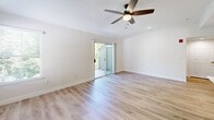 Located at 3301 Arena Blvd in Sacramento, CA, this thoughtfully designed one-bedroom, one-bathroom residence offers a clean, modern aesthetic throughout its well-utilized single floor. The open-concept kitchen and living room combination serves as the heart of the home, featuring light hardwood-style flooring, ceiling fans, and sliding glass doors that lead to a private balcony overlooking lush greenery. The kitchen stands out with its striking two-tone cabinetry — warm wood lower cabinets paired with crisp white upper cabinets — complemented by white quartz countertops, a tile backsplash, stainless steel appliances including a refrigerator, range, microwave, and dishwasher, plus a skylight that floods the space with natural light. The living area is bright and airy, with large windows and balcony access enhancing the sense of openness. The bedroom is comfortably sized with soft carpeting, a ceiling fan, and a window that brings in natural light. The bathroom features a full tub-shower combo, a modern white vanity with quartz countertop, and matching hardwood-style flooring. A dedicated in-unit laundry room with full-size washer and dryer and overhead cabinetry adds exceptional convenience to this well-appointed home.