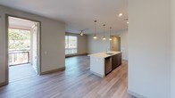 Located at 10110 Foothill Blvd in Rancho Cucamonga, CA, this modern two-story residence showcases contemporary design throughout. The open-concept main level features light wood-look flooring, neutral-toned walls, and abundant natural light streaming through large windows with horizontal blinds. The kitchen is a standout space, equipped with sleek dark wood cabinetry, stainless steel appliances including a refrigerator, gas range, and microwave, complemented by a white quartz island with an integrated sink and dishwasher. Stylish pendant lighting illuminates the kitchen and dining area, which flows seamlessly into the living room, outfitted with a ceiling fan and large windows offering outdoor views. The bedrooms feature plush carpeting, ceiling fans, and well-positioned windows that bring in generous natural light. The bathrooms are finished with modern touches, including a walk-in glass-enclosed shower with white subway tile, a soaking tub with matching tile surround, and a vanity with a backlit mirror and rich wood cabinetry. An attached garage with an automatic opener and concrete flooring provides convenient parking and storage. The overall aesthetic is clean, contemporary, and thoughtfully designed for comfortable living.