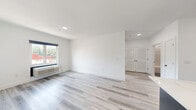Located at 102 Washington Ave in Belleville, NJ, this modern 2-bedroom, 2-bathroom residence offers a thoughtfully designed single-floor layout with clean lines and contemporary finishes throughout. Light gray luxury vinyl plank flooring runs seamlessly across the entire space, complementing the crisp white walls and creating a bright, cohesive aesthetic.

The kitchen is a standout feature, boasting a large quartz waterfall island with an undermount sink and pendant lighting overhead. Dark navy cabinetry pairs elegantly with stainless steel appliances — including a refrigerator, electric range, and over-the-range microwave — while a white tile backsplash adds a refined finishing touch.

Both bedrooms are comfortably sized, with the primary bedroom offering generous proportions. Each room features large windows with exterior views, allowing for ample natural light, and is equipped with individual climate control units.

The two bathrooms are finished in a modern style, featuring navy vanities with white countertops, sleek rounded mirrors, and soft gray tile flooring. One bathroom includes a full soaking tub with a tiled surround, while the other offers a refined, minimalist layout. Together, the spaces deliver a polished, move-in-ready home with upscale details throughout.