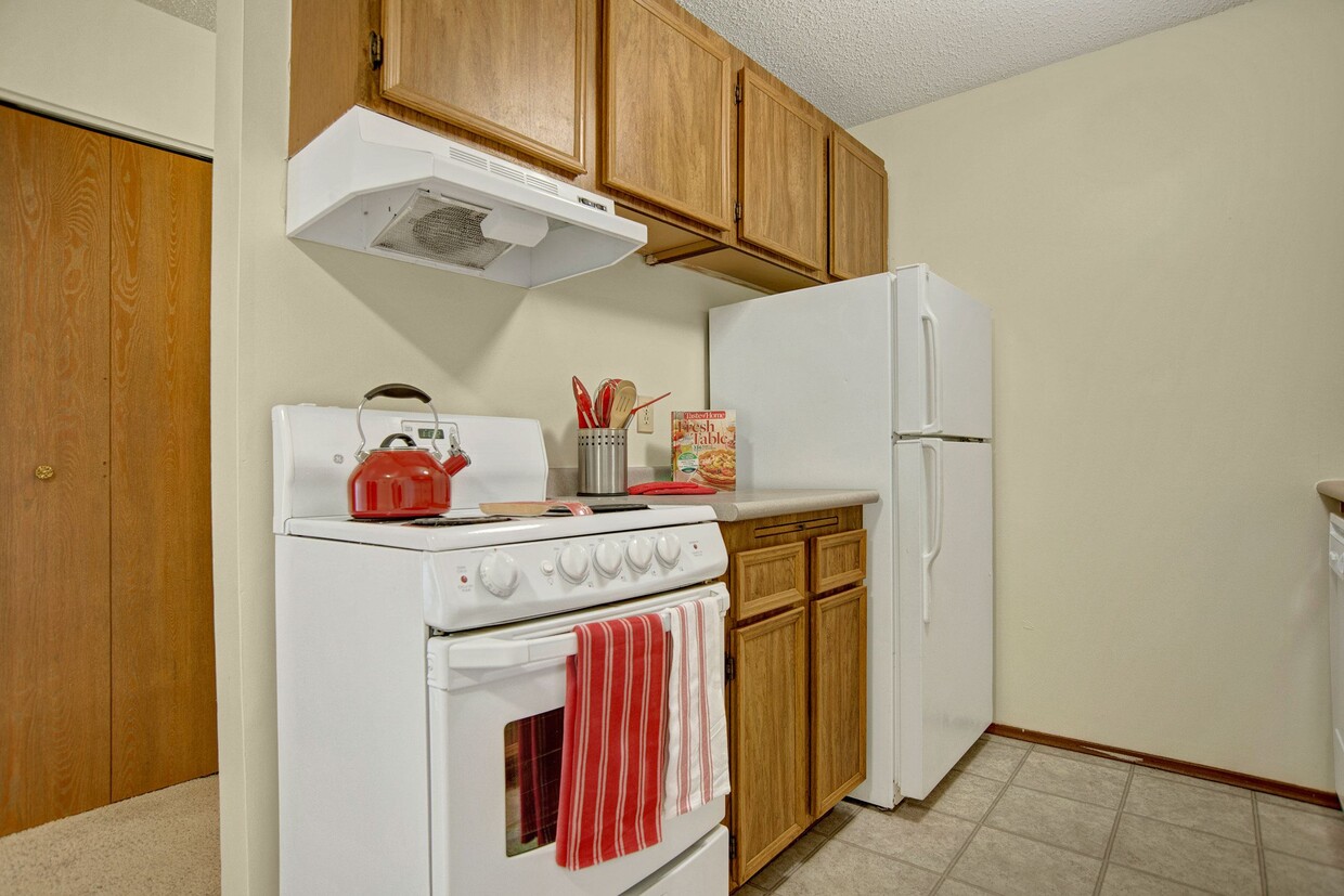 A kitchen with white appliances and light cabinetry - Forest Grove Village