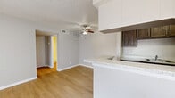 This thoughtfully designed 1-bedroom, 1-bathroom unit offers an efficient and functional layout across a single floor. The open-concept living, dining, and kitchen area forms the heart of the space, anchored by light hardwood-style flooring and neutral gray walls that create a clean, cohesive aesthetic. A ceiling fan provides comfort overhead, while a sliding glass door floods the living area with natural light and offers exterior access. The galley-style kitchen is outfitted with dark wood cabinetry, granite-look countertops, black appliances including a refrigerator, electric range, and dishwasher, and a breakfast bar that connects seamlessly to the living and dining area. The bedroom features plush carpeting, a window with blinds for natural light, and a textured ceiling. It leads directly into a walk-in closet complete with built-in shelving and hanging rods, offering generous storage. Two additional closets provide further organizational flexibility throughout the unit. The full bathroom includes a tiled shower-tub combination, toilet, and hardwood-style flooring. A textured ceiling is consistent throughout the space, adding subtle character to the overall design.