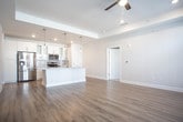 Located at 101 Kings Manor Dr in Williamsburg, Virginia, this single-floor residence offers a bright, modern interior with a cohesive design throughout. The open-concept living and kitchen area serves as the heart of the home, featuring light wood-tone flooring, recessed lighting, and a ceiling fan. The kitchen is well-appointed with white shaker cabinetry, glass-front upper cabinets, a subway tile backsplash, granite countertops, a central island with pendant lighting, and a full suite of stainless steel appliances including a refrigerator, range, and built-in microwave.

The bedrooms are finished with plush carpet flooring and ceiling fans, with multiple windows allowing for natural light and neighborhood views. The primary bedroom includes access to a spacious walk-in closet with built-in shelving. The primary bathroom features light wood-tone flooring, a white vanity with granite countertops, and a glass-enclosed walk-in shower with white subway tile and built-in niches. A second full bathroom provides a white vanity, granite countertops, and a tiled tub-shower combination with a sliding glass door.

A dedicated laundry area accommodates a full-sized washer and dryer, adding everyday convenience to this well-designed single-level home.