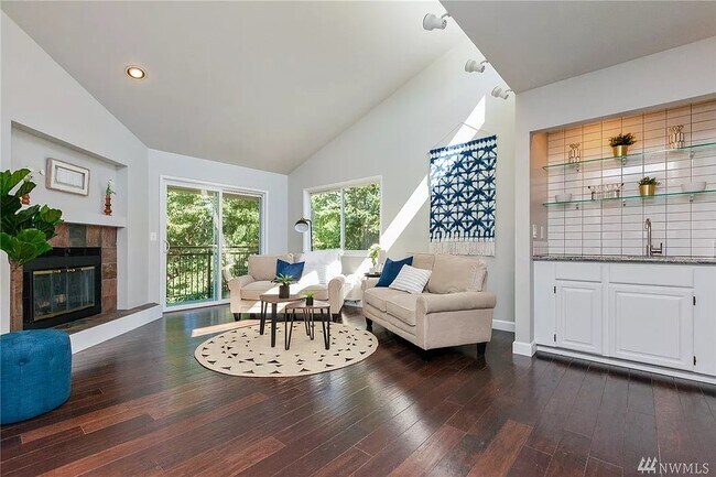 Sala de estar bien iluminada con hermosos pisos de madera noble. - 9800 Roosevelt Way NE