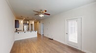 This well-appointed 1-bedroom, 1-bathroom residence in Lafayette, Louisiana offers a thoughtfully designed single-level layout with modern finishes throughout. The open-concept living and kitchen area serves as the heart of the home, featuring warm hardwood-style flooring, crown molding, and a ceiling fan with light kit. The kitchen stands out with rich dark cabinetry, granite countertops, stainless steel appliances, and a peninsula with bar seating, all illuminated by stylish pendant lighting.

A wide hallway with recessed lighting and crisp white panel doors connects the living area to the private quarters, lending the space a clean, organized feel. The bedroom is generously sized, offering multiple windows with natural light, a ceiling fan, and direct access to both a walk-in closet with built-in wire shelving and the full bathroom. The bathroom is well-equipped with a dark vanity, granite countertop, wall-mounted storage cabinet, and a glass-enclosed tile shower.

A dedicated laundry room with a washer hookup and additional wire shelving adds everyday convenience. Throughout the space, neutral tones, consistent flooring, and thoughtful details create a cohesive and comfortable living environment.