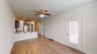 This well-appointed 1-bedroom, 1-bathroom residence in Lafayette, Louisiana offers a thoughtfully designed single-level layout with modern finishes throughout. The open-concept living and kitchen area serves as the heart of the home, featuring warm hardwood-style flooring, crown molding, and a ceiling fan with light kit. The kitchen stands out with rich dark cabinetry, granite countertops, stainless steel appliances, and a peninsula with bar seating, all illuminated by stylish pendant lighting.

A wide hallway with recessed lighting and crisp white panel doors connects the living area to the private quarters, lending the space a clean, organized feel. The bedroom is generously sized, offering multiple windows with natural light, a ceiling fan, and direct access to both a walk-in closet with built-in wire shelving and the full bathroom. The bathroom is well-equipped with a dark vanity, granite countertop, wall-mounted storage cabinet, and a glass-enclosed tile shower.

A dedicated laundry room with a washer hookup and additional wire shelving adds everyday convenience. Throughout the space, neutral tones, consistent flooring, and thoughtful details create a cohesive and comfortable living environment.