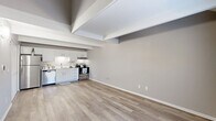 Located at 2701 NE 7th St in Ocala, Florida, this two-story home offers a practical and modern layout spread across two floors. The main floor hosts the primary living areas, including an open-concept kitchen and living room finished with light wood-look flooring and exposed ceiling beams that add architectural character. The kitchen is well-appointed with crisp white shaker cabinetry, a subway tile backsplash, stainless steel appliances including a refrigerator, dishwasher, and range, and a double-basin sink — all contributing to a clean, functional aesthetic. A utility room and additional hallway spaces round out the ground floor. Upstairs, the two bedrooms are carpeted for comfort and feature neutral gray walls. The primary bedroom benefits from a ceiling fan and direct closet access, while a second bedroom showcases an angled roofline with a charming dormer window that brings in natural light. Three closets are distributed throughout the home for ample storage. The full bathroom includes a tub-shower combination, a vanity with a white countertop, and tile flooring. A staircase connects the two levels, making efficient use of the home's compact yet well-organized footprint.