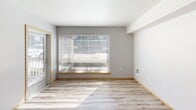 Located at 21800 Pacific Hwy S in Des Moines, Washington, this thoughtfully designed one-bedroom, two-bathroom unit offers a clean, modern aesthetic throughout its single-floor layout. Light wood-style flooring runs seamlessly across the living spaces, complementing the neutral gray walls and crisp white ceilings to create a bright, cohesive ambiance.

The open-concept kitchen and living area serves as the heart of the unit. The kitchen is well-appointed with warm wood-grain cabinetry extending floor to ceiling, light stone-toned countertops, a peninsula with a stainless steel sink, and a full suite of stainless steel appliances including a refrigerator, range, microwave, and dishwasher — ideal for both everyday cooking and entertaining.

The living area benefits from a large window that invites natural light and provides outdoor views. The bedroom is a comfortable, private retreat featuring its own window with blinds and light wood flooring. A dedicated closet provides convenient storage.

Both bathrooms are finished with hexagonal tile flooring, wood-grain vanity cabinetry, white countertops, and large mirrors with overhead lighting, offering a clean and contemporary feel. One bathroom includes in-unit laundry access, adding everyday convenience. The overall design balances modern finishes with functional simplicity.