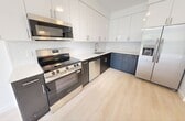Located at 23950 SW 129th Ave in Homestead, FL, this thoughtfully designed 2-bedroom, 1-bathroom unit offers 560 square feet of modern living space on a single floor. The open-concept layout connects the kitchen and living area seamlessly, featuring light wood-style flooring throughout. The contemporary kitchen is equipped with stainless steel appliances—including a side-by-side refrigerator with ice maker, range, microwave, and dishwasher—complemented by two-tone cabinetry with sleek white upper cabinets and dark lower cabinets, plus a clean white countertop and tile backsplash. Both bedrooms are bright and airy, each with ceiling fans, large windows framing lush tropical greenery, and abundant natural light. The primary bedroom measures 120 square feet and includes access to a dedicated closet with built-in wire shelving. The full bathroom features a tub/shower combo with brushed gold fixtures, a vanity with stone-look countertop, and matching flooring. A hallway leads to an in-unit stacked washer and dryer. A private balcony offers serene views of mature palm and shade trees, capturing the relaxed Florida lifestyle.