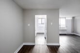 Located on the 11th floor at 40 Tuxedo Court in Toronto's Scarborough neighbourhood, this well-appointed 3-bedroom, 1-bathroom unit offers a functional and comfortable layout across a single floor. The unit features consistent grey laminate flooring throughout, complemented by clean white trim and neutral warm-toned walls that create a bright, cohesive atmosphere.

The galley-style kitchen is efficiently designed with white cabinetry, brushed nickel hardware, dark laminate countertops, a double stainless steel sink, and a blue tile backsplash. A window at the end of the kitchen brings in natural light and frames an outdoor view.

Two living areas provide flexible space for dining and lounging. The living room benefits from a large floor-to-ceiling window with access to an outdoor balcony, allowing ample natural light. Each of the three bedrooms features laminate flooring and individual windows with elevated views of the surrounding landscape. The primary bedroom is generously sized and includes a sliding-door closet with built-in rod storage. Additional bedrooms also offer closet access and baseboard heating.

The bathroom is cleanly finished with tile flooring, a white soaker tub and shower combo with tile surround, a dark granite-topped vanity, and a small window for ventilation. A hallway connects all rooms, completing this practical and well-lit unit.