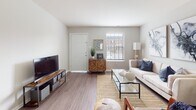 Located at 50 Pleasant Run Dr in Henrico, Virginia, this single-floor residence offers a thoughtfully designed layout with a clean, contemporary aesthetic throughout. Neutral gray tones and wood-look flooring run consistently across the space, creating a cohesive and warm ambiance.

The living room is an inviting, well-lit area featuring large windows with horizontal blinds that allow ample natural light to fill the room. The open layout comfortably accommodates a seating area alongside an entertainment setup, making it ideal for both relaxing and hosting.

Adjacent to the living room, the dining area is an intimate space accented by a pendant light fixture and a round mirror, adding a stylish touch. A nearby walk-in closet provides convenient additional storage.

The kitchen is equipped with white cabinetry, dark speckled countertops, and a stainless steel sink, offering a practical and clean workspace with generous counter and storage space.

The bedroom is a comfortable retreat featuring a large window that brings in natural light and generous closet space, including a built-in shelving system behind sliding doors. The bathroom features white cabinetry with dark countertops, subway tile backsplash, a framed mirror with overhead lighting, and a shower-tub combination — combining functionality with a tidy, classic aesthetic.