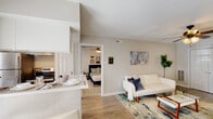 This single-floor residence in Metairie, Louisiana, offers a thoughtfully designed layout across two bedrooms and two full bathrooms. The open-concept living area features wood-look flooring, a ceiling fan, and neutral walls that create a bright, welcoming atmosphere. A textured ceiling adds character throughout the main living spaces, while large windows and French doors invite ample natural light.

The kitchen is well-equipped with white cabinetry accented by gold hardware, clean white countertops, a subway tile backsplash, a matte black faucet, and black stainless appliances. A pass-through counter with bar seating connects the kitchen to the living and dining area, enhancing the open feel.

Both bedrooms are carpeted and include ceiling fans. The primary bedroom features a direct connection to its en-suite bathroom and offers generous closet space. The second bedroom is distinguished by French doors that provide additional natural light. Each bathroom is finished with white vanities, wood-look flooring, and shower-tub combinations.

Storage is addressed with double closet doors in the living area, and the overall layout flows efficiently from room to room, making the space feel functional and comfortable.