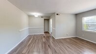 Located at 908 Lake Village Dr in Chesapeake, Virginia, this single-floor, 2-bedroom, 1-bathroom home offers a well-organized and efficiently designed layout. The living room is bright and welcoming, featuring wood-look laminate flooring, neutral gray walls, chair-rail detailing, and windows that bring in generous natural light. The open flow connects seamlessly to a hallway leading to the rest of the home. The galley-style kitchen is thoughtfully appointed with white shaker cabinets, light countertops, a double sink, and black appliances including a gas range, dishwasher, and refrigerator, along with a window overlooking the outdoors. Both bedrooms are carpeted and include ceiling fans, ample natural light, and dedicated closets — one bedroom features a spacious walk-in closet, while the other has a wide sliding-door closet. The full bathroom is clean and functional, finished in white with a tub-shower combination and wood-look flooring. Two hallways connect the living areas to the bedrooms and bathroom, and additional closet storage is conveniently distributed throughout. The home presents a move-in-ready, neutral aesthetic throughout.