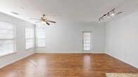 Located in Austin, TX near Lakeline Mall, this well-appointed 2-bedroom, 2-bathroom single-floor home offers a thoughtfully designed layout with quality finishes throughout. The living room makes a strong first impression with rich hardwood-style flooring, crown molding, a ceiling fan, track lighting, and multiple windows that invite abundant natural light. A private exterior door adds convenient access directly from the living area. The kitchen is a standout feature, boasting dark espresso cabinetry, granite countertops, a tile backsplash, stainless steel appliances, and pendant lighting over a breakfast bar peninsula — all complemented by the same warm hardwood-style flooring. The spacious primary bedroom features crown molding, a ceiling fan, natural light, and access to a generous walk-in closet with multi-level shelving and hanging rods. The primary bathroom is equipped with a dual-sink vanity topped with granite, dark cabinetry, and a well-lit mirror. The second bedroom offers plush carpeting, crown molding, ample natural light, and its own closet. Both bedrooms provide comfortable, private retreats. Crown molding is carried consistently throughout the home, lending a polished, cohesive aesthetic to every room.