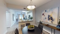 This single-floor residence offers a thoughtfully designed open-concept layout that seamlessly connects the kitchen, dining, and living areas. The kitchen is outfitted with stainless steel appliances, crisp white cabinetry, granite countertops, and a peninsula with bar seating — ideal for casual dining or entertaining. Light wood-style flooring runs throughout the main living spaces, adding warmth and continuity.

The dining area is defined by a stylish pendant light and is positioned adjacent to the kitchen, providing a natural flow for gatherings. The living room is bright and inviting, featuring a ceiling fan, large sliding glass door, and direct access to an outdoor patio with views of lush greenery.

Both bedrooms are comfortably sized, filled with natural light from large windows, and finished with the same wood-style flooring. The primary bedroom benefits from garden views, while the secondary bedroom offers a serene, neutral retreat.

The bathrooms are cleanly finished with granite vanity countertops, undermount sinks, and brushed nickel fixtures. One bathroom includes a full tub-shower combination with tile surround. Throughout the residence, a soft, neutral color palette and consistent modern finishes create a cohesive and welcoming ambiance.