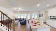 Located in Lawrenceville, GA, this well-appointed two-story home offers three bedrooms, three bathrooms, two office spaces, and a thoughtfully designed layout spread across two generously sized floors. The main level opens into a bright, open-concept living area where the kitchen, dining, and living room flow seamlessly together. The kitchen is a standout feature, showcasing white shaker cabinetry, stainless steel appliances, a gray subway tile backsplash, and a large granite-topped island with bar seating — ideal for both cooking and entertaining. Large windows and a rear door flood the living area with natural light and provide views of the surrounding greenery, while a ceiling fan adds to the comfortable ambiance. Hardwood-style flooring extends throughout the main level, lending warmth and continuity. Upstairs, the spacious primary bedroom offers plush carpeting and generous square footage, accompanied by two additional bedrooms and well-appointed bathrooms, including a clean tub-shower combination. Two dedicated office spaces provide flexibility for remote work or study. A convenient laundry room and multiple closets complete the practical layout. A chandelier-lit dining area with wainscoting paneling and abundant natural light adds an elegant touch to the home's overall inviting character.