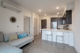 Located at 1547 Pacific Avenue in Santa Cruz, California, this modern one-bedroom, one-bathroom residence offers a thoughtfully designed layout with contemporary finishes throughout. Light wood-look flooring flows seamlessly across the entire space, complementing the clean, neutral color palette and creating a cohesive, airy feel.

The kitchen is a standout feature, showcasing dark wood-grain cabinetry paired with striking marble-veined quartz countertops. A full suite of stainless steel appliances — including a range, over-the-range microwave, dishwasher, and refrigerator — ensures full functionality. The peninsula with bar seating provides casual dining space while opening to the living area, enhancing the sense of openness. A large window adjacent to the kitchen allows natural light to pour in, offering views of the surrounding Santa Cruz neighborhood.

The bedroom is a serene retreat with recessed lighting, a window framing neighborhood views, and clean white walls that create a calm, restful ambiance.

The bathroom is well-appointed with a wood-toned vanity, white quartz countertop, a large mirror, and a shower-tub combination, maintaining the modern aesthetic found throughout the home.

Compact yet efficiently organized, this residence delivers a polished urban living experience in the heart of Santa Cruz.