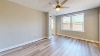 Located at 6817 Georgia Ave NW, Unit 205 in Washington, DC, this one-bedroom, one-bathroom residence offers a practical and well-appointed layout across a single floor. The unit features light-toned hardwood-style flooring throughout, creating a cohesive and easy-to-maintain living environment.

The spacious primary bedroom is a standout feature, offering generous room for furnishings and includes a ceiling fan with light fixture, a textured ceiling, a closet with double panel doors, and a window that allows natural light to filter in. A second window in the main living area further brightens the space with outdoor views of the surrounding neighborhood.

The kitchen is accessed through a distinctive arched entryway framed by decorative columns, lending architectural character to the unit. Inside, it is equipped with wood-toned upper cabinetry, a black refrigerator, a gas range, a dishwasher, and ample counter space — all efficiently arranged for functional cooking.

The bathroom is finished in a clean, bright palette with white walls, white tile wainscoting, a vanity with under-sink storage, a medicine cabinet mirror, and wall-mounted lighting above. The overall design of the unit is neutral and move-in ready, making it a practical choice in the Georgia Avenue corridor of Washington, DC.