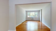 Located at 100 Rock Rd in Hawthorne, NJ, this single-floor residence offers a clean, well-maintained layout with a cohesive design throughout. The living and dining areas flow seamlessly together through an arched passageway, both finished with warm, honey-toned hardwood floors and crisp white trim that lend a bright, airy feel to the space. Natural light fills the living area through a large front-facing window, while a wall-unit air conditioner and baseboard heating ensure year-round comfort. A ceiling fan adds an additional layer of functionality to the dining area, which also features a front door entry with its own window, framing views of the surrounding greenery.

The bedroom is generously proportioned, with a wide window overlooking mature trees, baseboard heating, and the same hardwood flooring found throughout the unit. The full bathroom is finished with white tile flooring, a tiled soaking tub, a white vanity with cabinet storage, and a small window for ventilation and natural light.

The kitchen is equipped with rich oak cabinetry, granite countertops, a white tile backsplash, a stainless steel dishwasher, and a gas range, offering both style and practicality. The hardwood flooring extends into the kitchen, maintaining a consistent aesthetic across the entire residence.