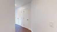 Located in the heart of downtown San Diego, this contemporary 2-bedroom, 2-bathroom residence offers a sleek, modern aesthetic across a thoughtfully designed single-level floor plan. Warm hardwood-style flooring flows throughout, complementing the clean white walls and crisp architectural details found in every room.

The living areas are anchored by dramatic floor-to-ceiling windows with bold black frames, flooding the space with natural light and offering sweeping panoramic views of the San Diego skyline. The kitchen is outfitted with stainless steel appliances, a gas range, built-in microwave, and a generous island topped with elegant marble-veined quartz countertops, paired with light wood and white cabinetry for a refined, contemporary look.

Both bedrooms are bright and well-proportioned, each benefiting from large windows with city views. The primary bedroom includes access to a spacious walk-in closet with custom built-in shelving and a luxurious en-suite bathroom featuring light wood cabinetry, stone-look tile flooring, dark marble-style wall tiles, and a glass-enclosed shower. The second bathroom offers a soaking tub with full tile surround and matte black fixtures. A dedicated walk-in closet with ample built-in storage adds further practicality to this polished urban residence.