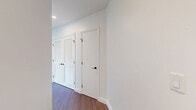 Located in the heart of downtown San Diego, this contemporary 2-bedroom, 2-bathroom residence offers a sleek, modern aesthetic across a thoughtfully designed single-level floor plan. Warm hardwood-style flooring flows throughout, complementing the clean white walls and crisp architectural details found in every room.

The living areas are anchored by dramatic floor-to-ceiling windows with bold black frames, flooding the space with natural light and offering sweeping panoramic views of the San Diego skyline. The kitchen is outfitted with stainless steel appliances, a gas range, built-in microwave, and a generous island topped with elegant marble-veined quartz countertops, paired with light wood and white cabinetry for a refined, contemporary look.

Both bedrooms are bright and well-proportioned, each benefiting from large windows with city views. The primary bedroom includes access to a spacious walk-in closet with custom built-in shelving and a luxurious en-suite bathroom featuring light wood cabinetry, stone-look tile flooring, dark marble-style wall tiles, and a glass-enclosed shower. The second bathroom offers a soaking tub with full tile surround and matte black fixtures. A dedicated walk-in closet with ample built-in storage adds further practicality to this polished urban residence.