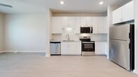 Located at 360 Orleans Ave in Santa Rosa Beach, FL, this thoughtfully designed one-bedroom, one-bathroom residence offers a clean, modern aesthetic throughout its efficiently utilized single-floor layout. Light-toned luxury vinyl plank flooring flows seamlessly through the entire space, complementing the neutral warm-white walls and crisp white trim that create a bright, airy ambiance.

The kitchen is well-appointed with white shaker-style cabinetry extending to the ceiling for ample storage, granite-look countertops, a subway tile backsplash, and a full suite of stainless steel appliances including a refrigerator, electric range, built-in microwave, and dishwasher. Recessed lighting illuminates the space effectively.

The bedroom is generously proportioned, featuring two large windows with white horizontal blinds that invite natural light and offer views of the surrounding neighborhood. A ceiling fan provides year-round comfort. Adjacent to the bedroom is a dedicated walk-in closet outfitted with wire shelving and hanging rods for organized storage.

The bathroom offers a full tub/shower combination with a curved curtain rod and a vanity topped with granite-look counters. A dedicated in-unit laundry room houses a full-size Whirlpool washer and dryer with overhead wire shelving, adding everyday convenience to this well-rounded Santa Rosa Beach residence.