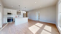 Located at 7831 E Union Ave in Denver, CO, this thoughtfully designed 2-bedroom, 2-bathroom residence offers a clean, modern aesthetic across a single level. The open-concept living, dining, and kitchen area serves as the heart of the home, featuring light wood-tone flooring, recessed lighting, and large windows that fill the space with natural sunlight. The kitchen is appointed with white cabinetry, a subway tile backsplash, stainless steel appliances, a central island with pendant lighting, and a warm wood open shelf accent — ideal for both everyday living and entertaining. The bedrooms are carpeted for comfort, each offering generous closet space and windows with views of the surrounding Denver neighborhood. The primary bedroom includes a ceiling fan and its own dedicated bathroom access. Both bathrooms are finished with white cabinetry, black hardware accents, and wood-tone flooring, lending a cohesive contemporary style throughout. Additional conveniences include a dedicated laundry room, utility room, and four closets providing ample storage. The overall palette of soft neutrals and crisp whites creates a bright, welcoming ambiance throughout this well-appointed Denver residence.