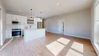 Located at 7831 E Union Ave in Denver, CO, this thoughtfully designed 2-bedroom, 2-bathroom residence offers a clean, modern aesthetic across a single level. The open-concept living, dining, and kitchen area serves as the heart of the home, featuring light wood-tone flooring, recessed lighting, and large windows that fill the space with natural sunlight. The kitchen is appointed with white cabinetry, a subway tile backsplash, stainless steel appliances, a central island with pendant lighting, and a warm wood open shelf accent — ideal for both everyday living and entertaining. The bedrooms are carpeted for comfort, each offering generous closet space and windows with views of the surrounding Denver neighborhood. The primary bedroom includes a ceiling fan and its own dedicated bathroom access. Both bathrooms are finished with white cabinetry, black hardware accents, and wood-tone flooring, lending a cohesive contemporary style throughout. Additional conveniences include a dedicated laundry room, utility room, and four closets providing ample storage. The overall palette of soft neutrals and crisp whites creates a bright, welcoming ambiance throughout this well-appointed Denver residence.